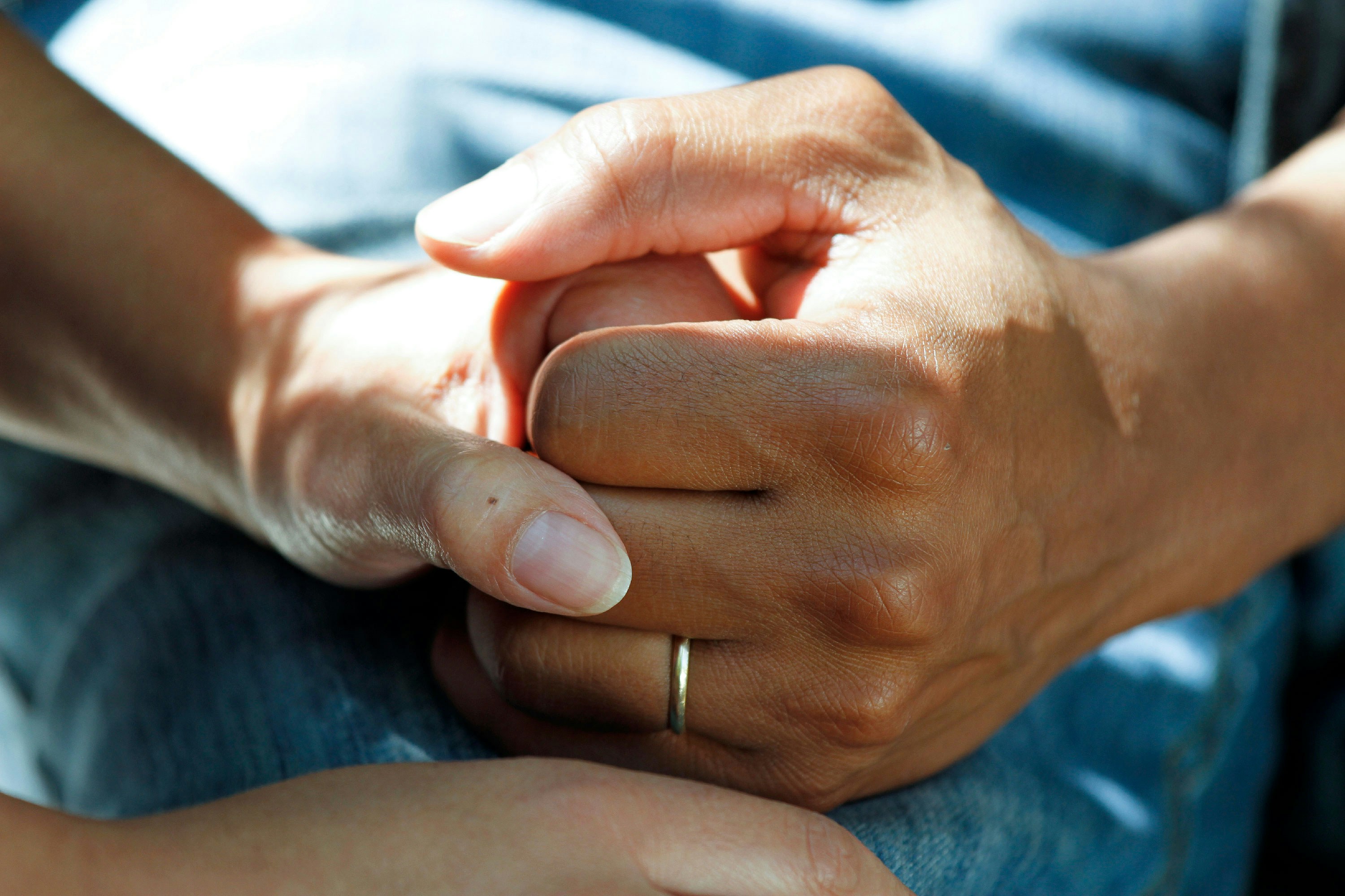 Two hands holding each other in support