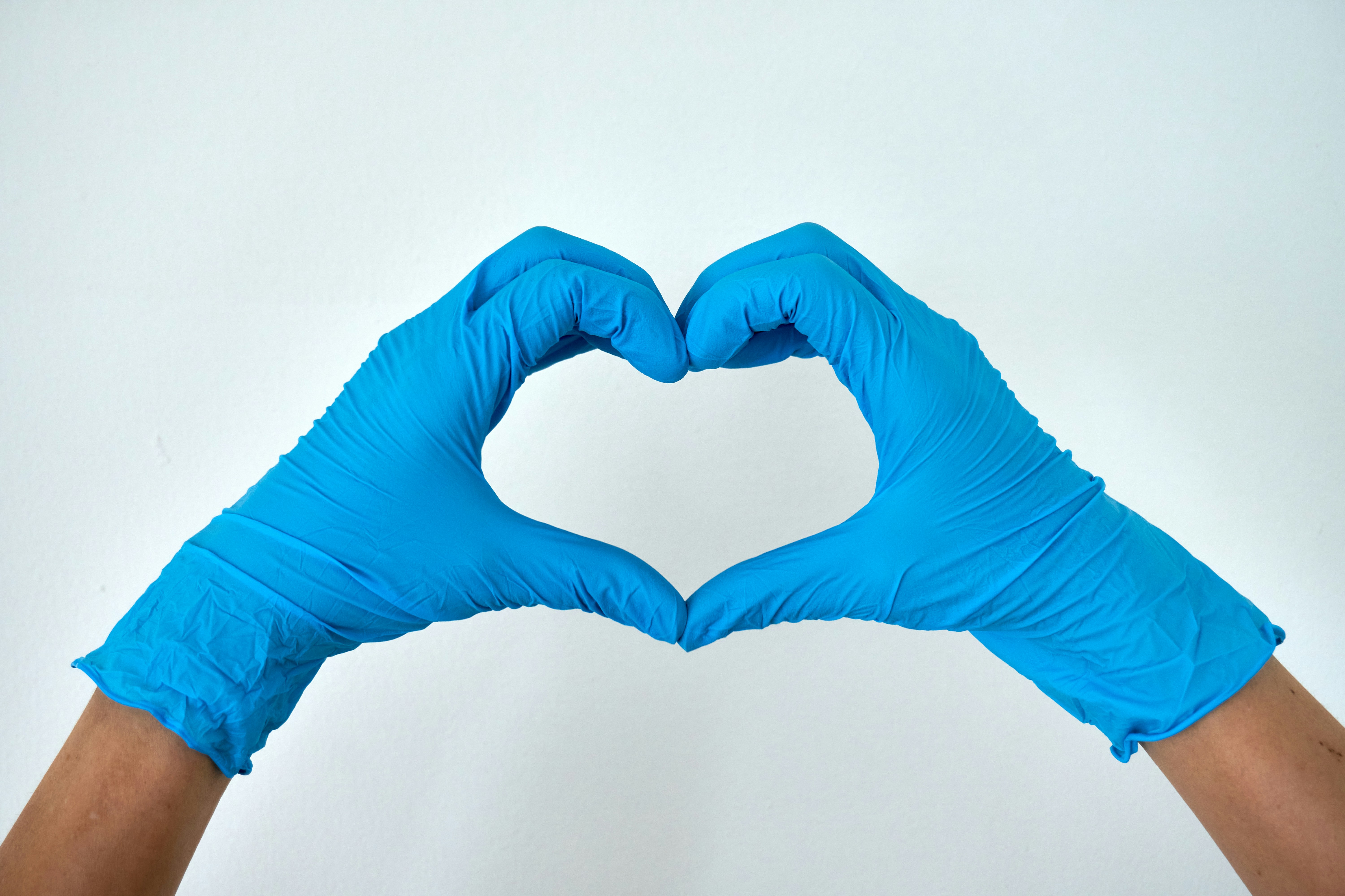 Medical gloved hands forming a heart